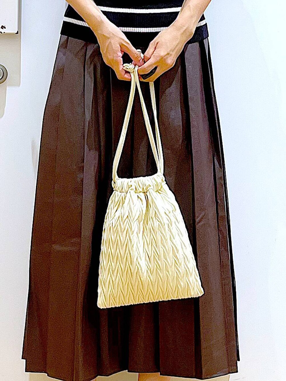 ホワイト系のショルダーバッグ、ブラック系のローファー、ブラック系のニット/セーターを着用したレディースの秋コーディネートの9枚目の写真