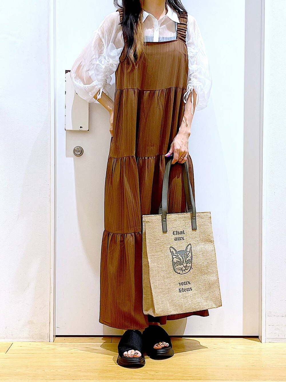 ブラック系のサンダル、ベージュ系のワンピース、グレー系のトートバッグを着用したレディースの夏コーディネートの6枚目の写真