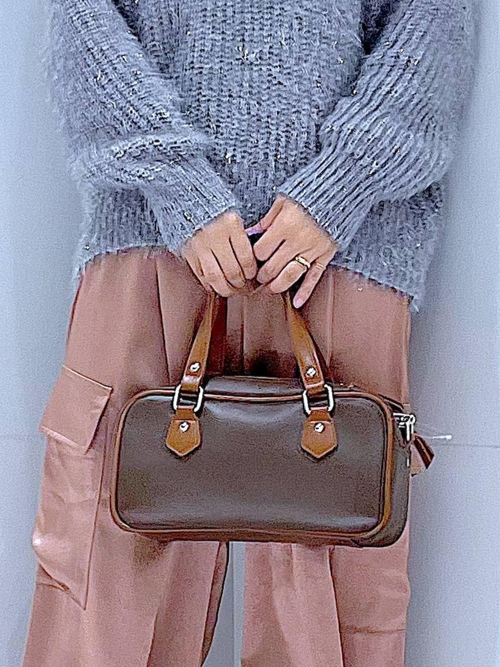 ブラック系のブーツ、ブラウン系のショルダーバッグ、ピンク系のカーゴパンツを着用したレディースの冬コーディネートの9枚目の写真