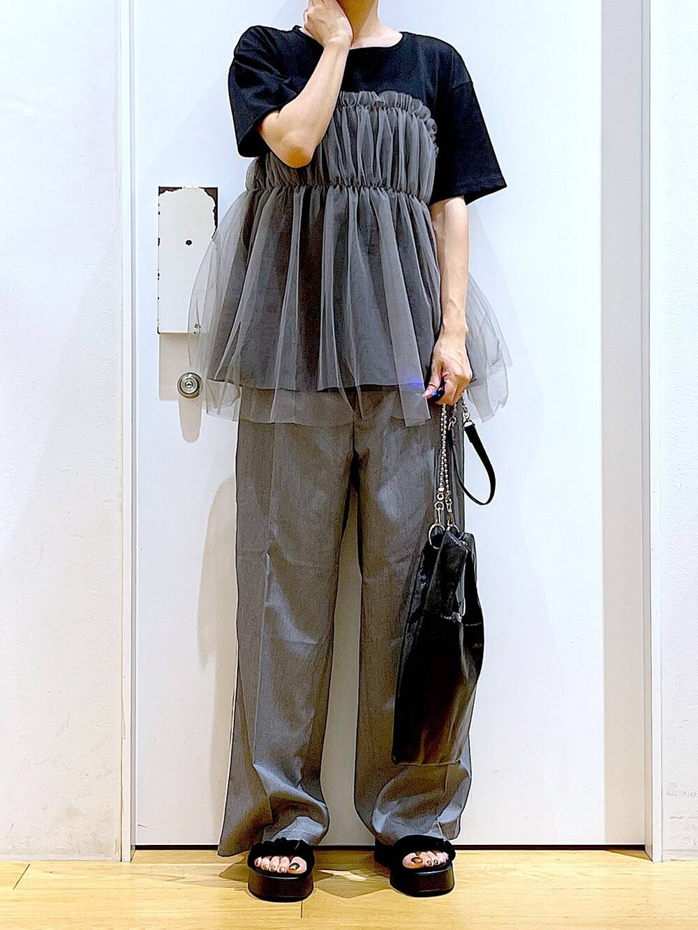 ブラック系のショルダーバッグ、ブラック系のサンダル、ブラック系のTシャツ/カットソーを着用したレディースの夏コーディネートの6枚目の写真