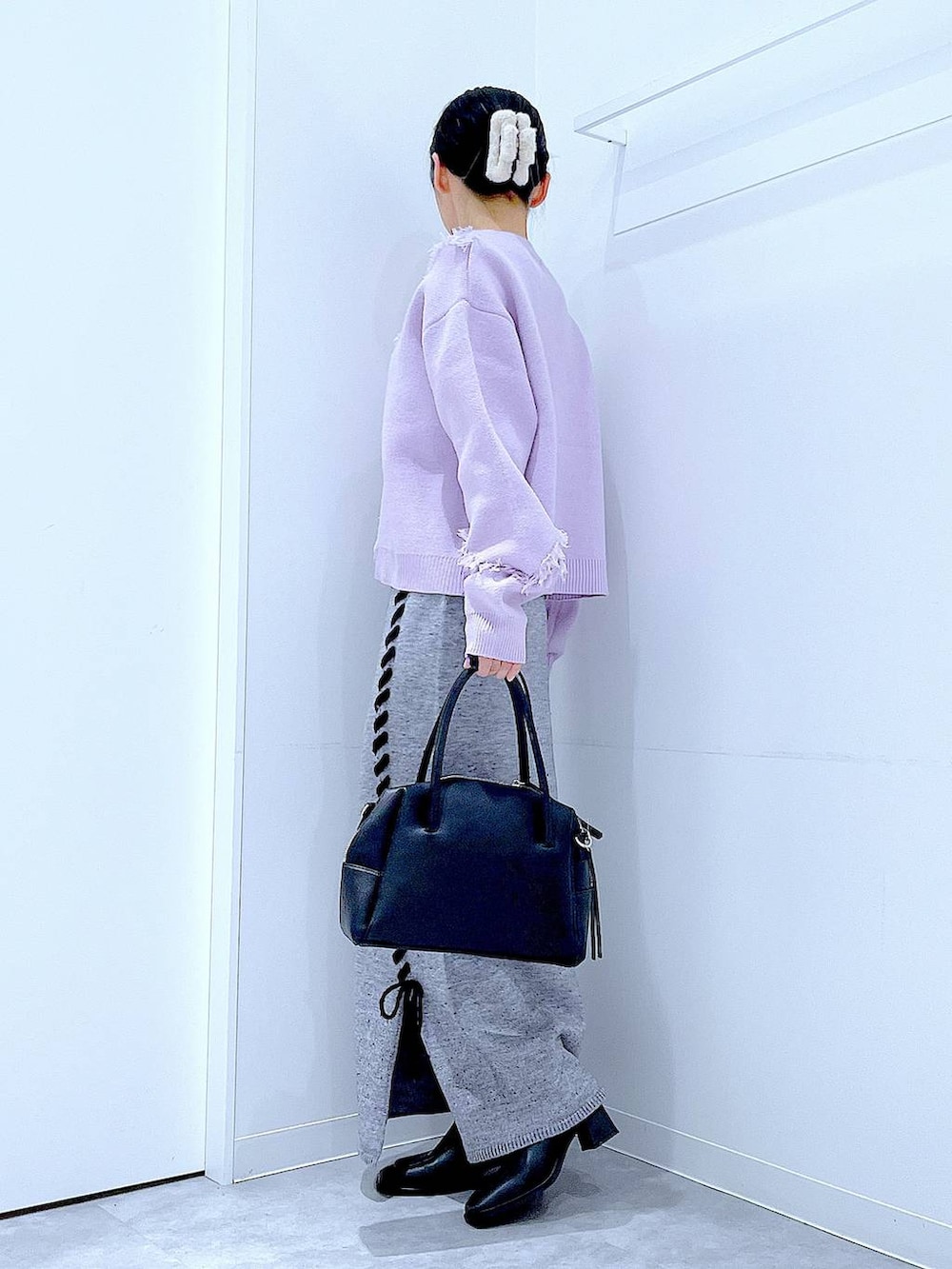 ブラック系のボストンバッグ、グレー系のスカート、ブラック系のブーツを着用したレディースの冬コーディネートの3枚目の写真