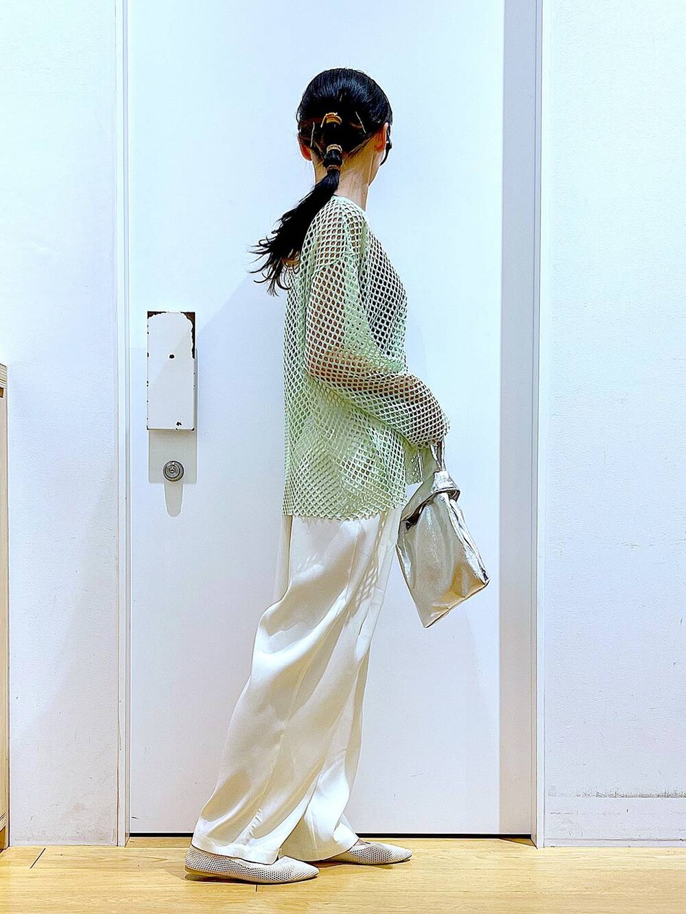 シルバー系のショルダーバッグ、グリーン系のTシャツ/カットソー、ホワイト系のパンプスを着用したレディースの春コーディネートの4枚目の写真