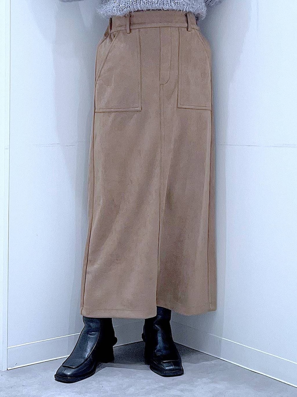 ブラック系のブーツ、ブラック系のショルダーバッグ、ブラウン系のスカートを着用したレディースの冬コーディネートの8枚目の写真