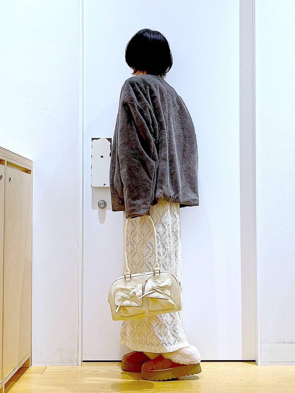 ベージュ系のスリッポン、ホワイト系のハンドバッグ、グレー系のスウェットを着用したレディースの秋コーディネートの3枚目の写真