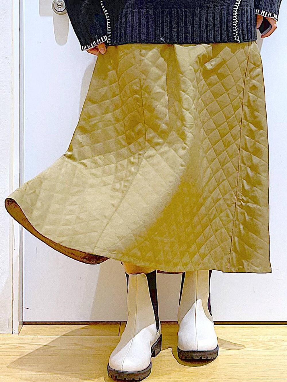 シルバー系のトートバッグ、ベージュ系のブーツ、ブラック系のニット/セーターを着用したレディースの冬コーディネートの8枚目の写真