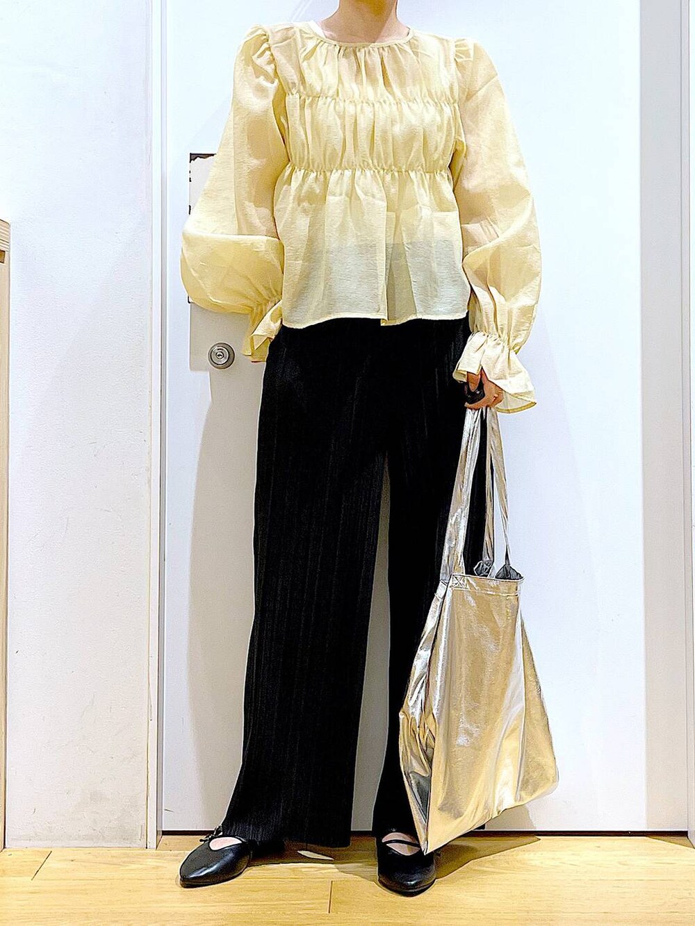 シルバー系のトートバッグ、ブラック系のその他パンツ、ブラック系のパンプスを着用したレディースの秋コーディネートの6枚目の写真