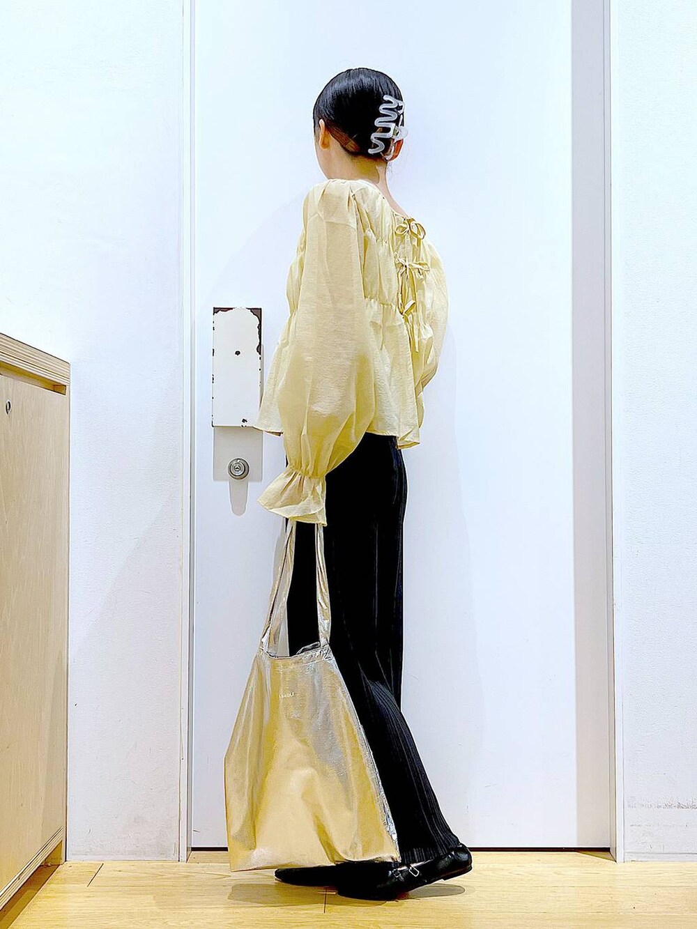 シルバー系のトートバッグ、ブラック系のその他パンツ、ブラック系のパンプスを着用したレディースの秋コーディネートの3枚目の写真