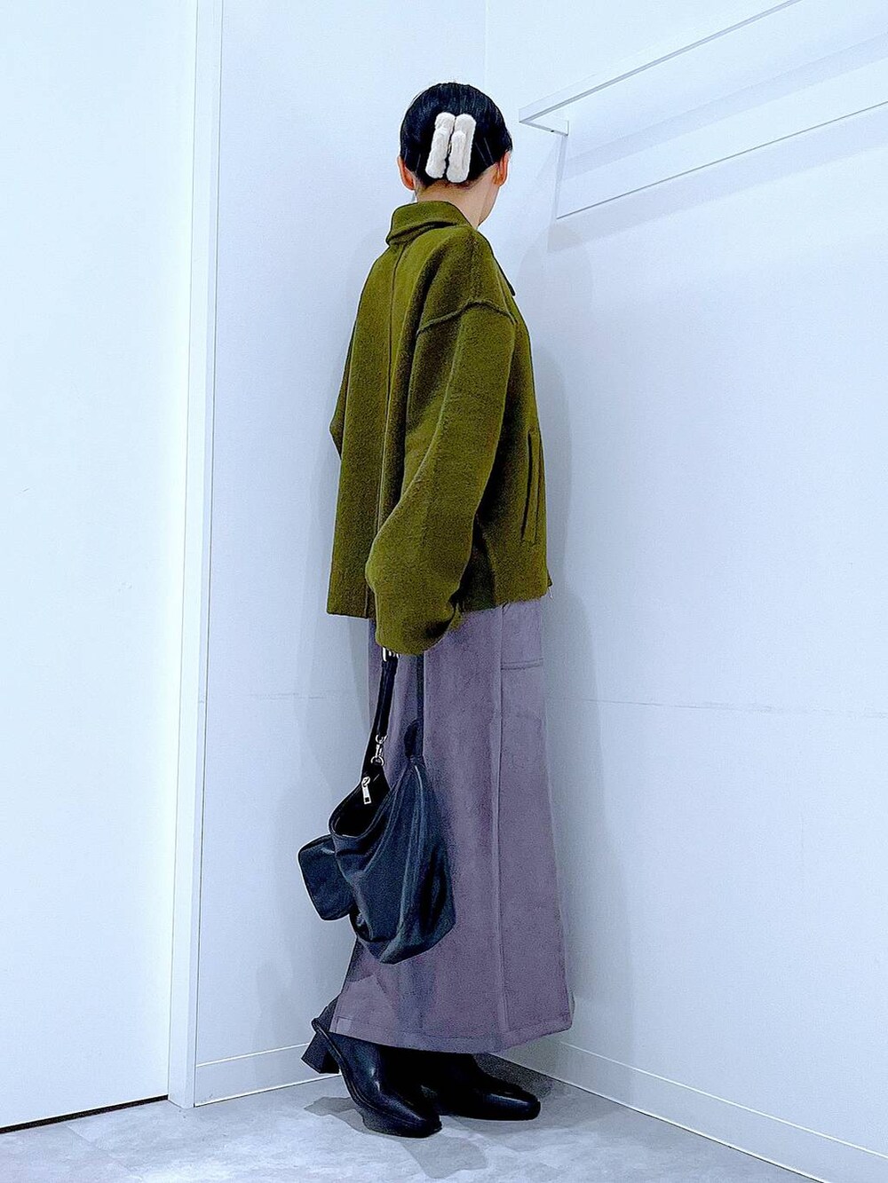 グリーン系のブルゾン、ブラック系のブーツ、ブラック系のショルダーバッグを着用したレディースの秋コーディネートの4枚目の写真