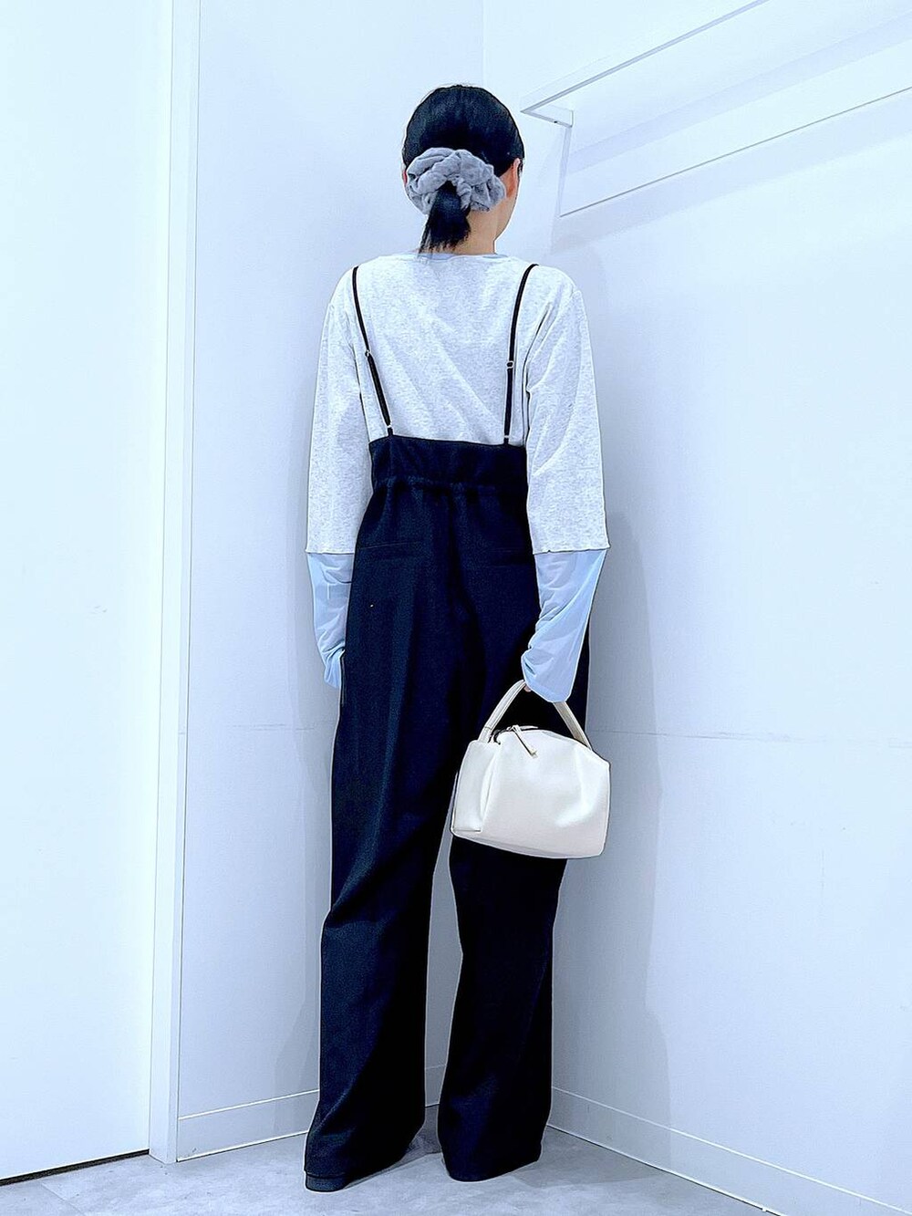 ホワイト系のショルダーバッグ、ブラック系のローファー、ブラック系のサロペット/オーバーオールを着用したレディースの春コーディネートの5枚目の写真