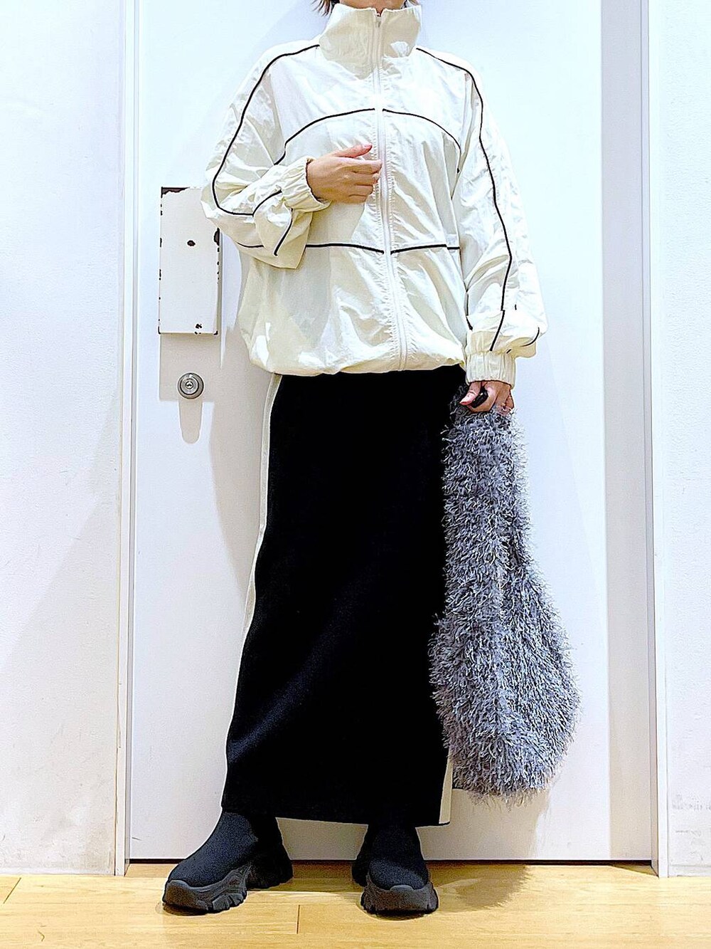 ブラック系のスカート、ベージュ系のブルゾン、グレー系のショルダーバッグを着用したレディースの秋コーディネートの6枚目の写真