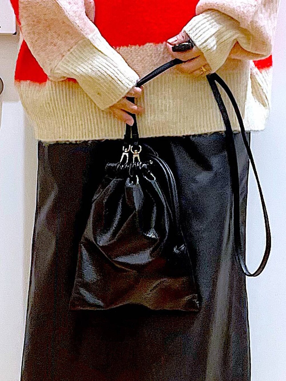 ベージュ系のブーツ、ブラック系のスカート、ブラック系のショルダーバッグを着用したレディースの冬コーディネートの9枚目の写真