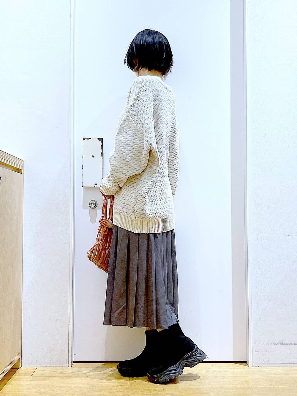 ベージュ系のニット/セーター、ピンク系のショルダーバッグ、ブラック系のブーツを着用したレディースの冬コーディネートの3枚目の写真