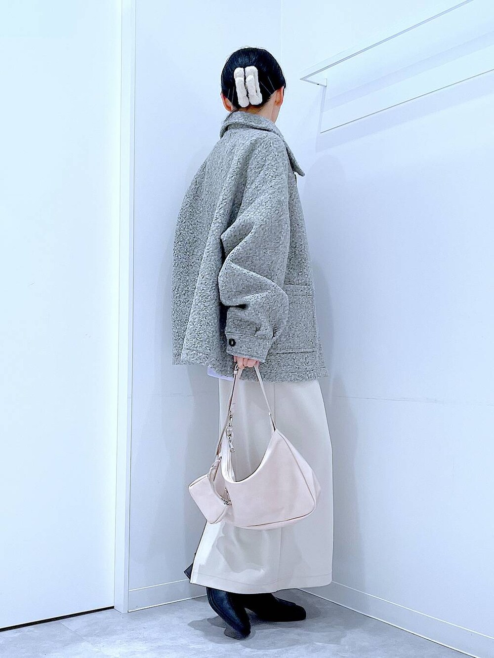 ベージュ系のスカート、グレー系のブルゾン、ブラック系のブーツを着用したレディースの秋コーディネートの4枚目の写真