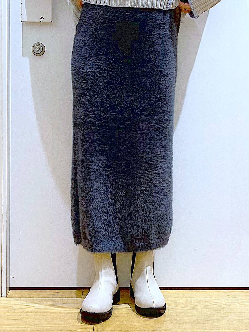 グレー系のトートバッグ、ベージュ系のブーツ、グレー系のスカートを着用したレディースの冬コーディネートの8枚目の写真