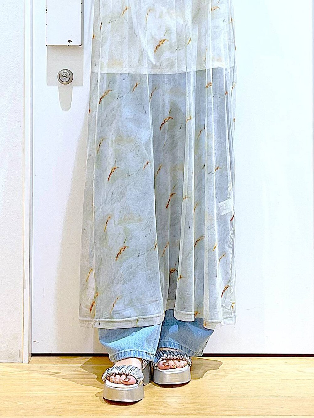 ブルー系のデニムパンツ、ブラック系のトートバッグ、ホワイト系のTシャツ/カットソーを着用したレディースの夏コーディネートの8枚目の写真