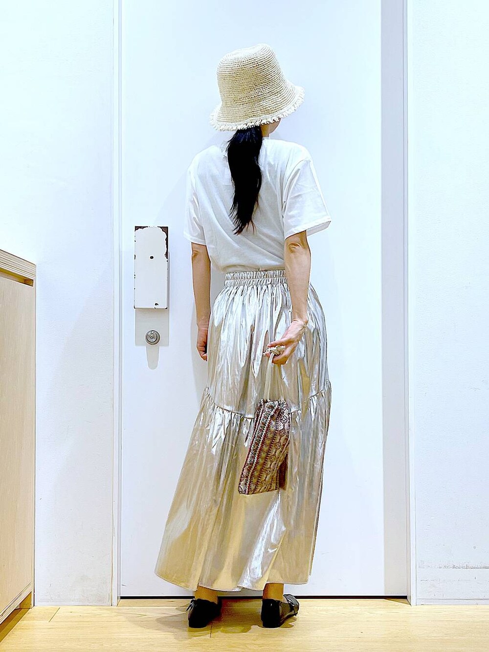 ピンク系のショルダーバッグ、シルバー系のスカート、ホワイト系のTシャツ/カットソーを着用したレディースの夏コーディネートの5枚目の写真