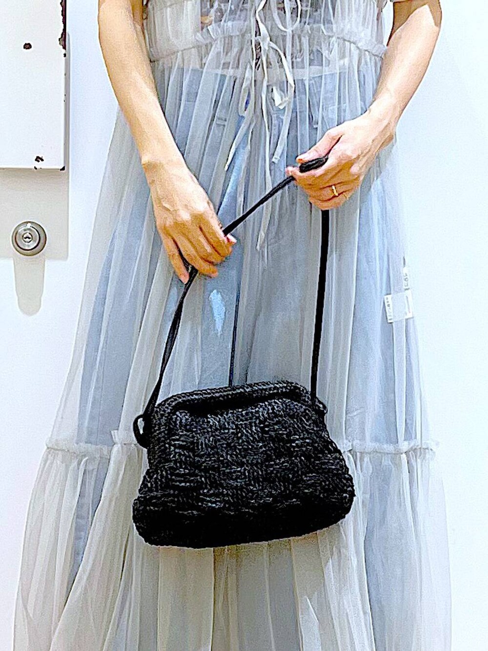 グレー系のワンピース、ブルー系のデニムパンツ、ブラック系のショルダーバッグを着用したレディースの夏コーディネートの9枚目の写真