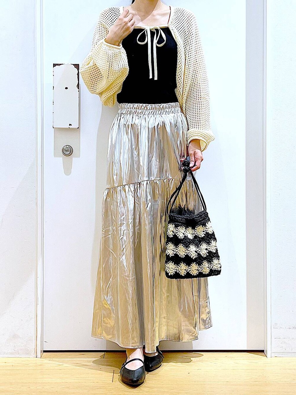 ホワイト系のカーディガン/ボレロ、ブラック系のパンプス、ブラック系のショルダーバッグを着用したレディースの夏コーディネートの6枚目の写真