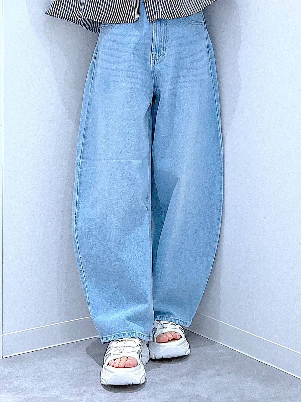 ブルー系のデニムパンツ、ベージュ系のトートバッグ、ホワイト系のスニーカーを着用したレディースの夏コーディネートの8枚目の写真