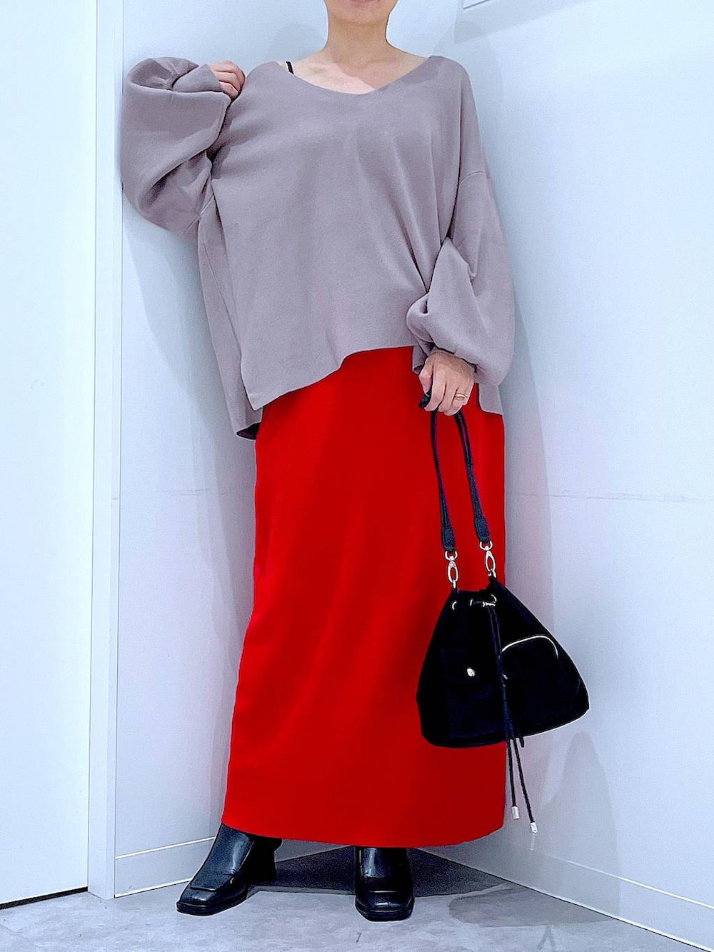 ブラウン系のニット/セーター、ブラック系のショルダーバッグ、ブラック系のブーツを着用したレディースの冬コーディネートの6枚目の写真