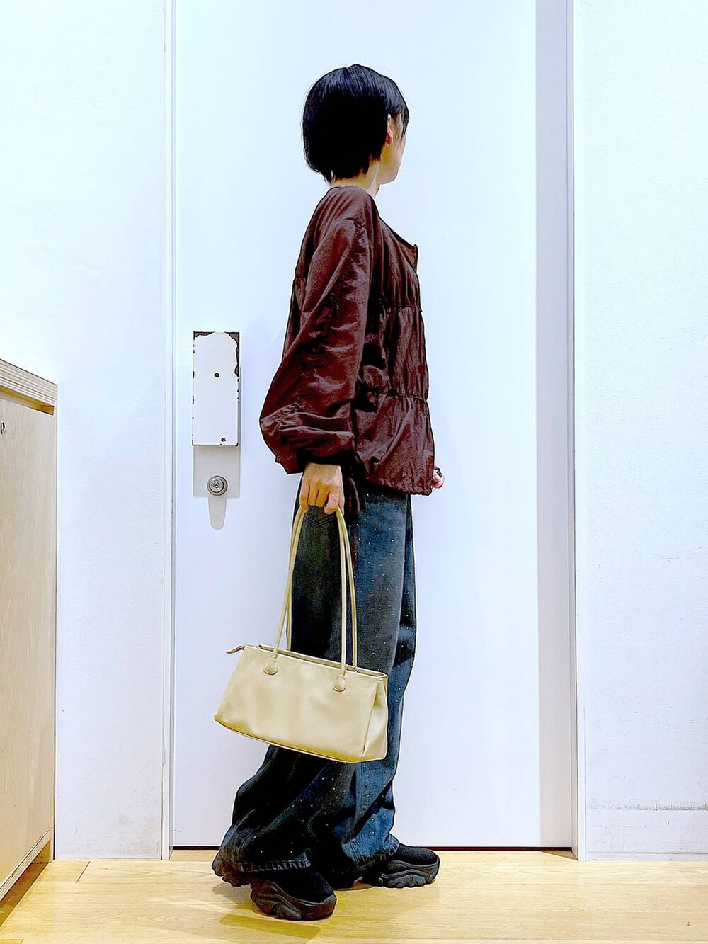 ブラック系のブーツ、ベージュ系のトートバッグ、ブラウン系のブルゾンを着用したレディースの冬コーディネートの4枚目の写真