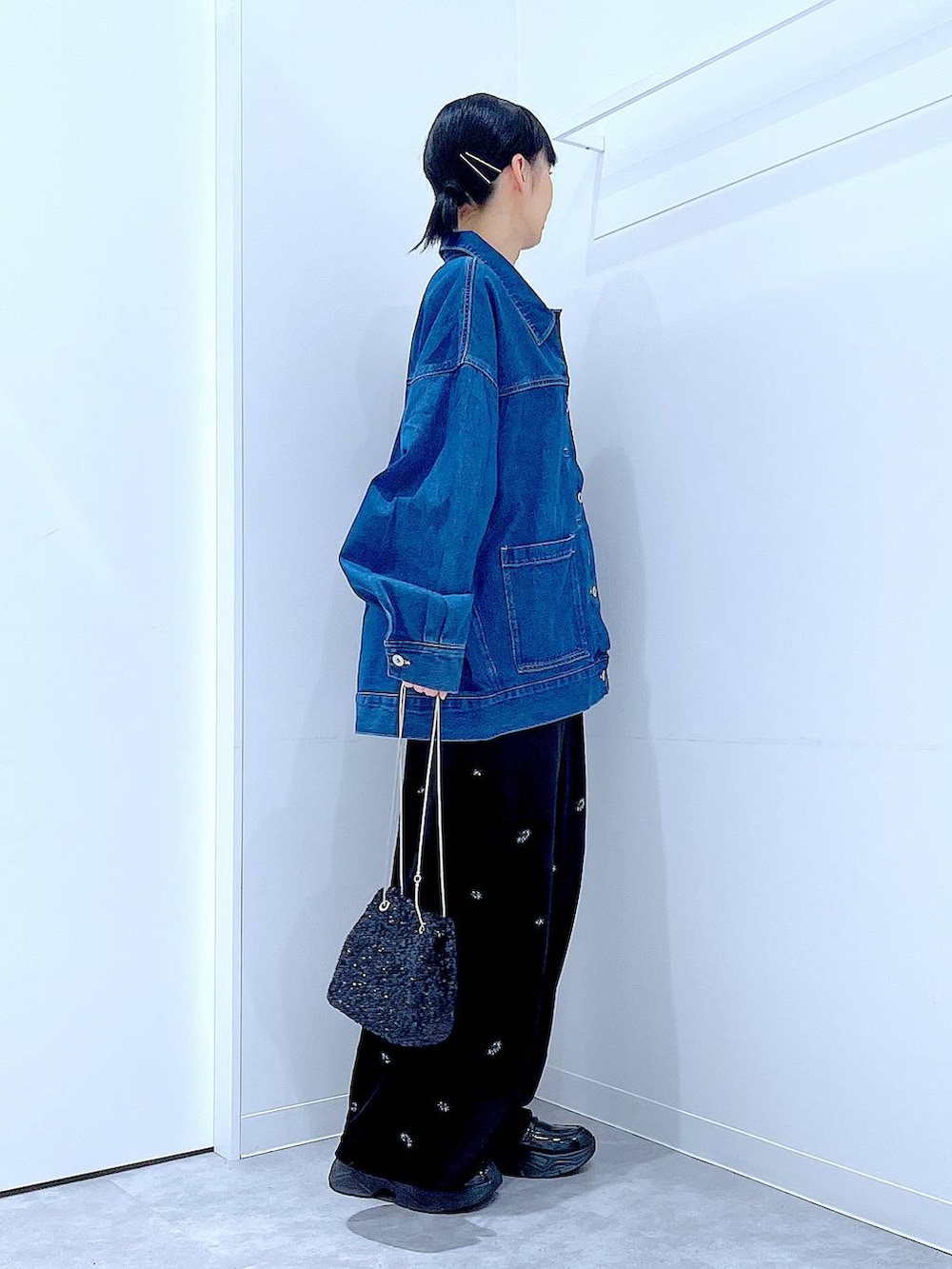 ブラック系のショルダーバッグ、ブラック系のローファー、ブルー系のデニムジャケットを着用したレディースの秋コーディネートの4枚目の写真