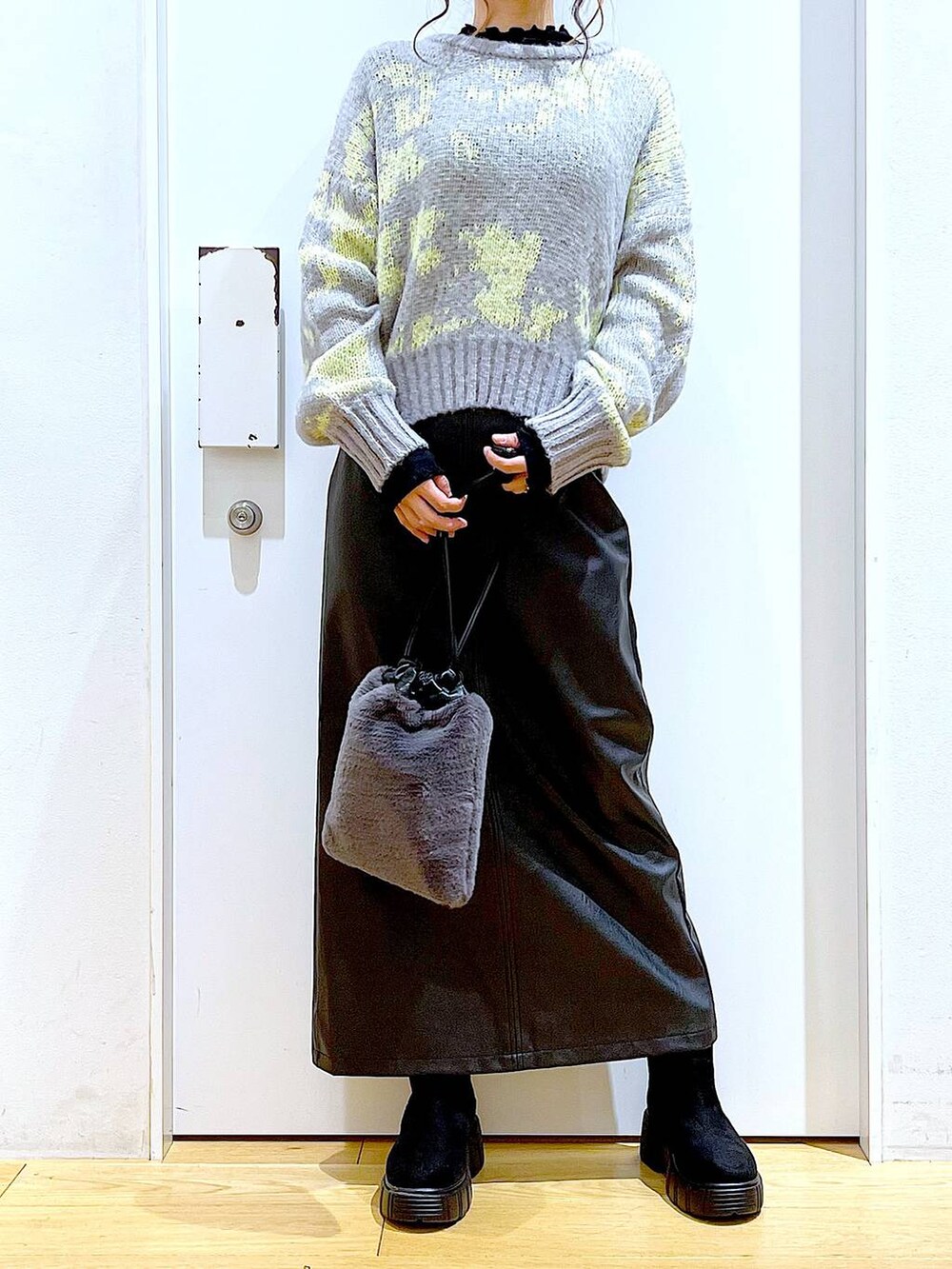 ブラック系のTシャツ/カットソー、グレー系のショルダーバッグ、ブラック系のブーツを着用したレディースの冬コーディネートの6枚目の写真