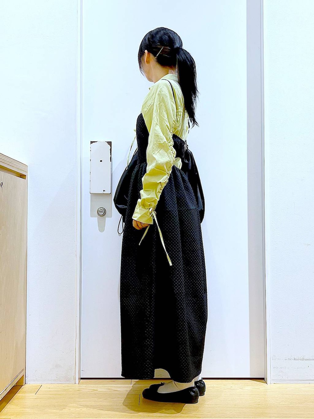 グリーン系のシャツ/ブラウス、ブラック系のバレエシューズ、ブラック系のショルダーバッグを着用したレディースの春コーディネートの3枚目の写真