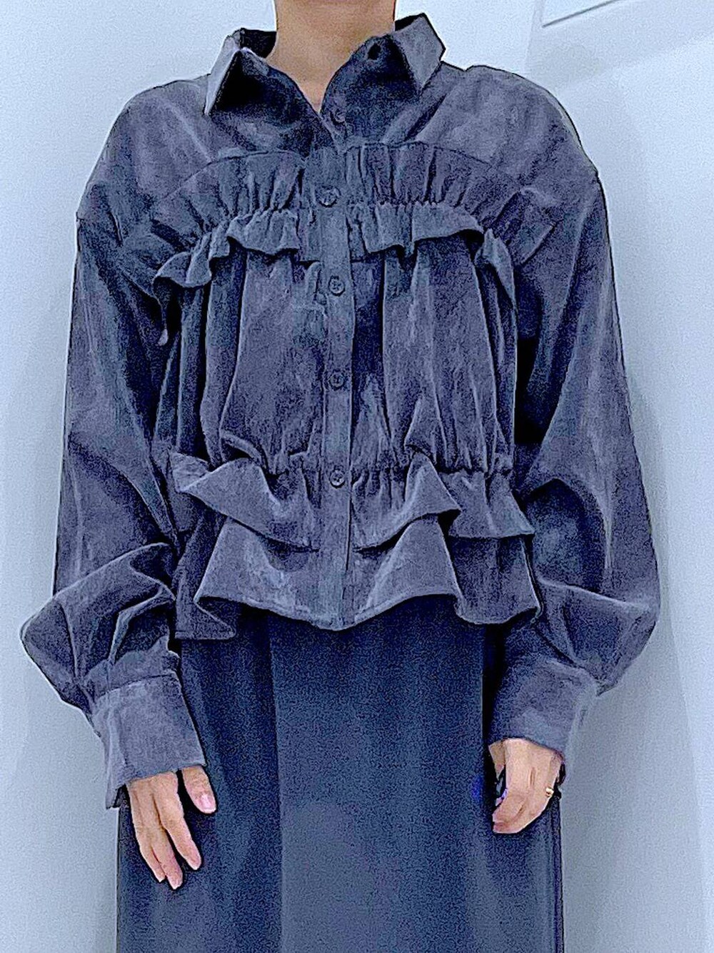 グレー系のスカート、ブラック系のブーツ、ブラック系のハンドバッグを着用したレディースの秋コーディネートの7枚目の写真