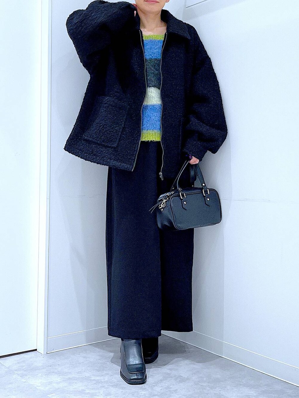 ブラック系のスカート、ブラック系のブルゾン、ブラック系のブーツを着用したレディースの冬コーディネートの6枚目の写真