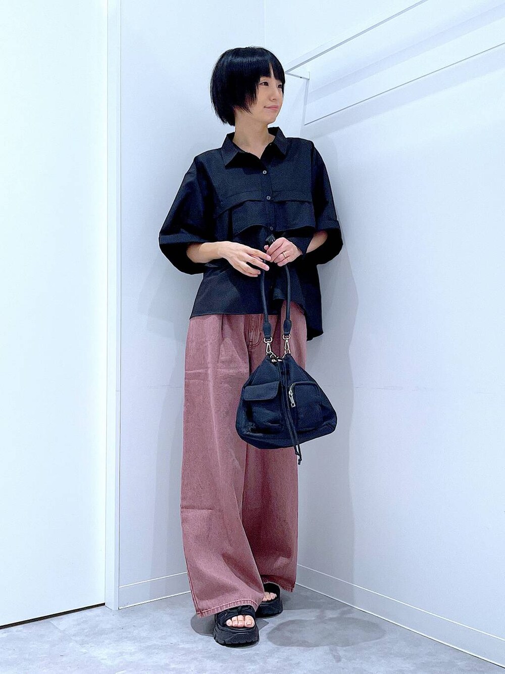 ブラック系のスニーカー、ブラック系のショルダーバッグ、ブラック系のシャツ/ブラウスを着用したレディースの秋コーディネートの2枚目の写真