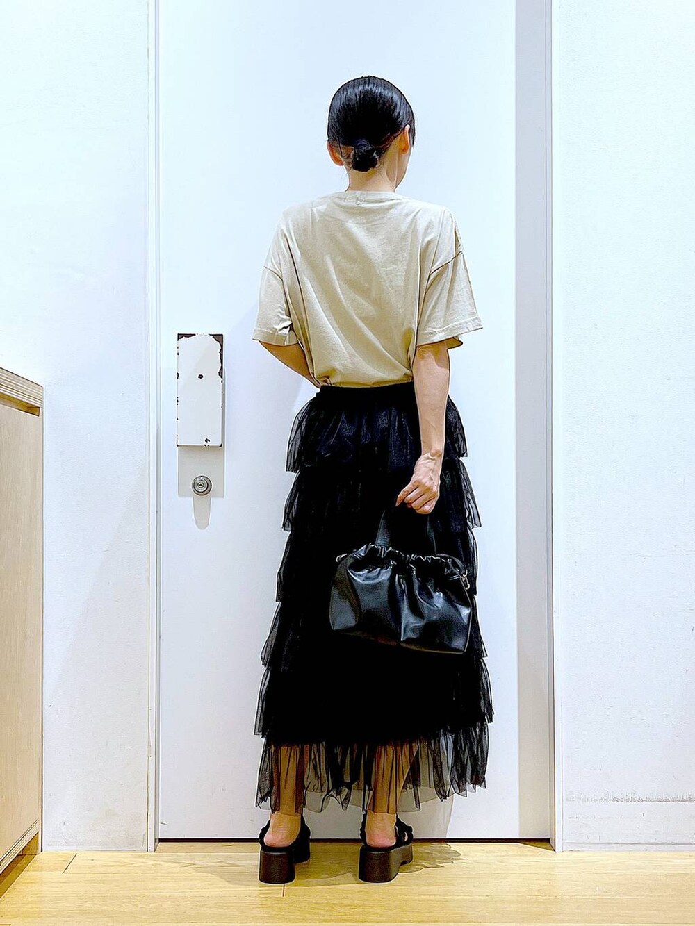 ブラック系のサンダル、ブラック系のショルダーバッグ、ブラック系のスカートを着用したレディースの夏コーディネートの5枚目の写真