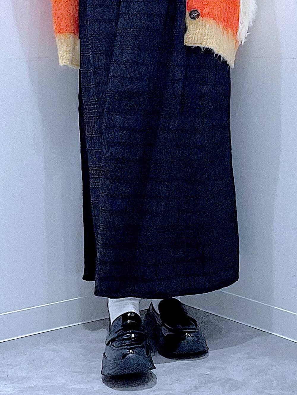 ブラック系のショルダーバッグ、ブラック系のローファー、オレンジ系のカーディガン/ボレロを着用したレディースの秋コーディネートの8枚目の写真