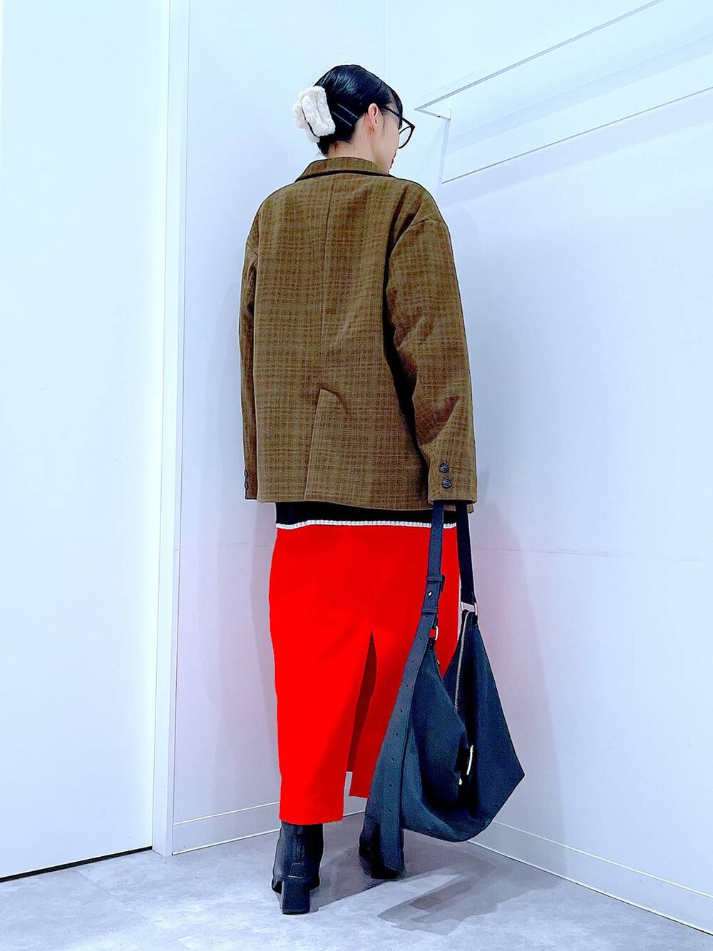 レッド系のスカート、ブラック系のブーツ、ブラック系のショルダーバッグを着用したレディースの冬コーディネートの5枚目の写真