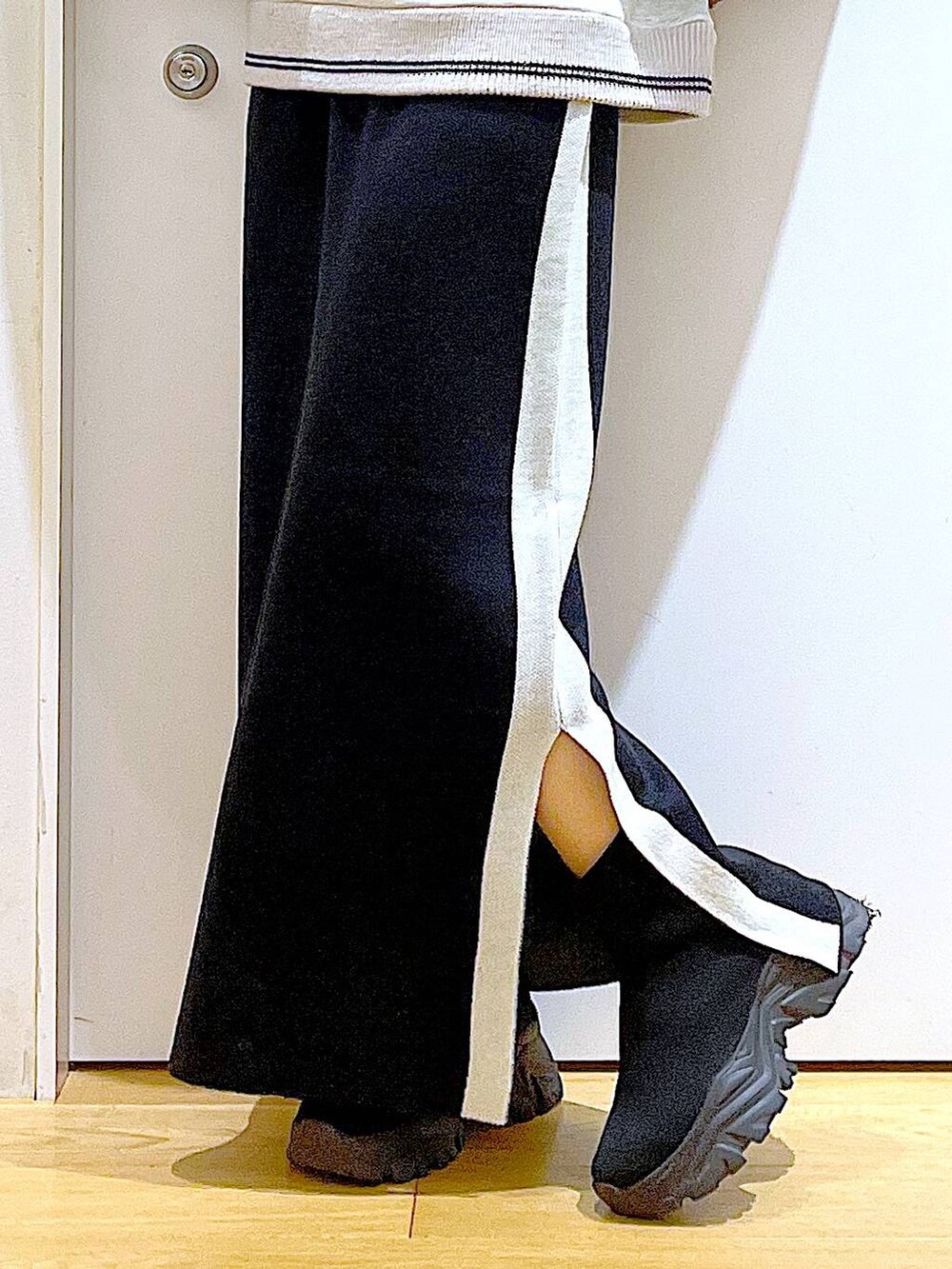 ブラック系のスカート、ブラック系のショルダーバッグ、ブラック系のブーツを着用したレディースの冬コーディネートの8枚目の写真