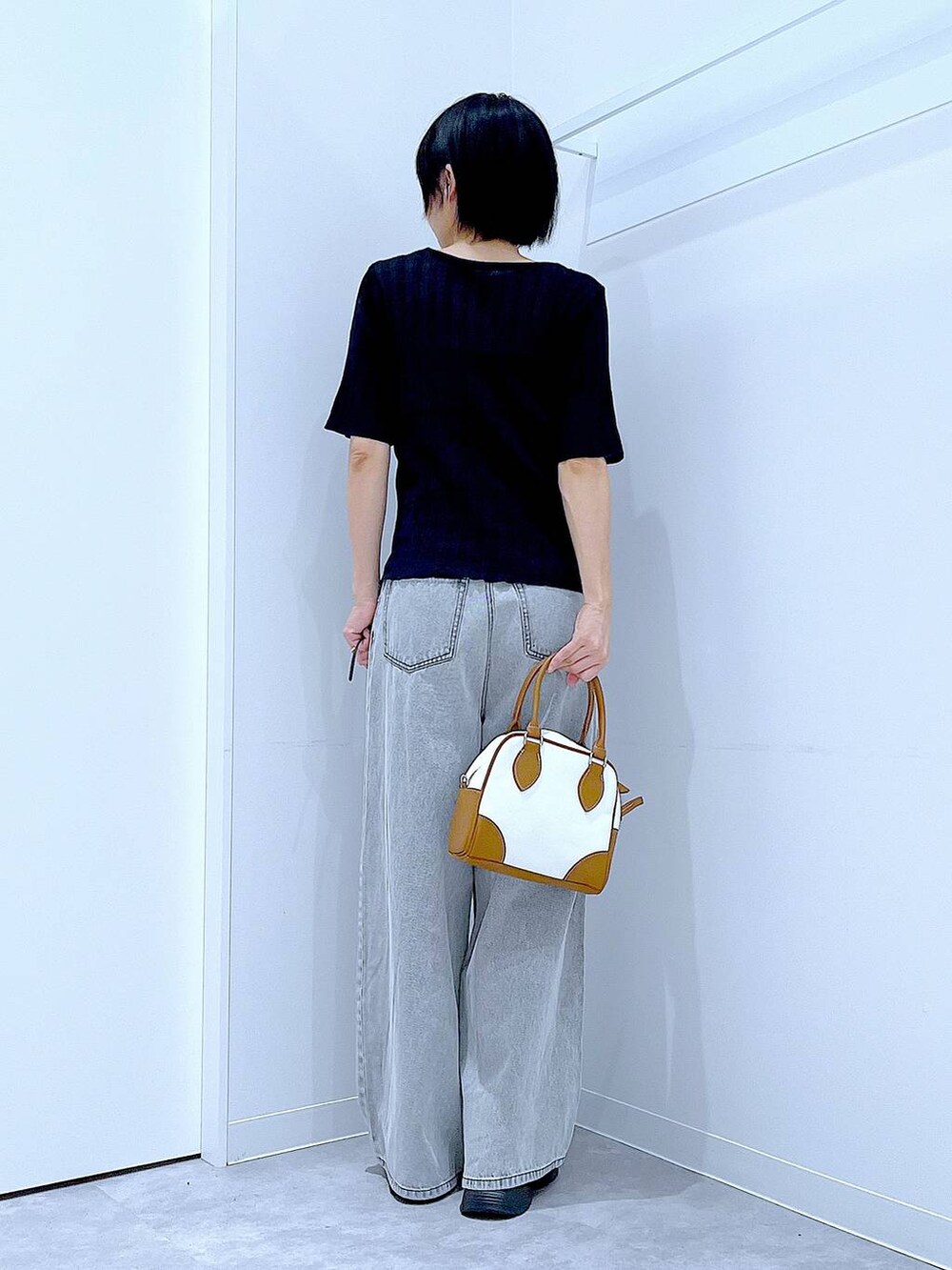 ブラック系のローファー、ホワイト系のハンドバッグ、ブラック系のニット/セーターを着用したレディースの秋コーディネートの5枚目の写真