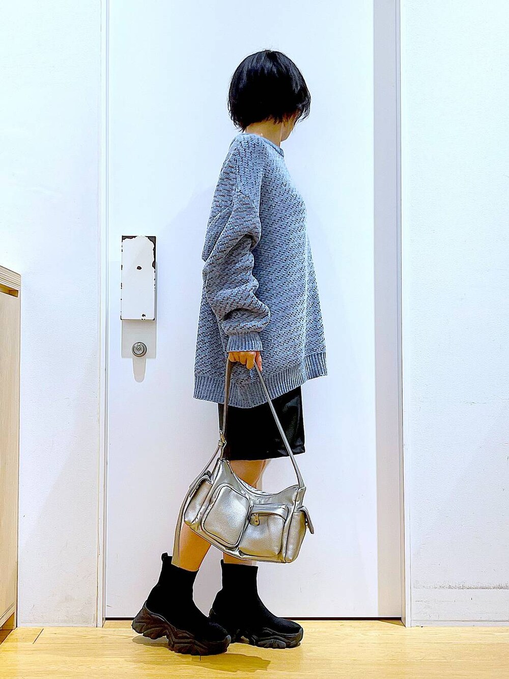 ブルー系のニット/セーター、ブラック系のブーツ、その他のショルダーバッグを着用したレディースの冬コーディネートの4枚目の写真