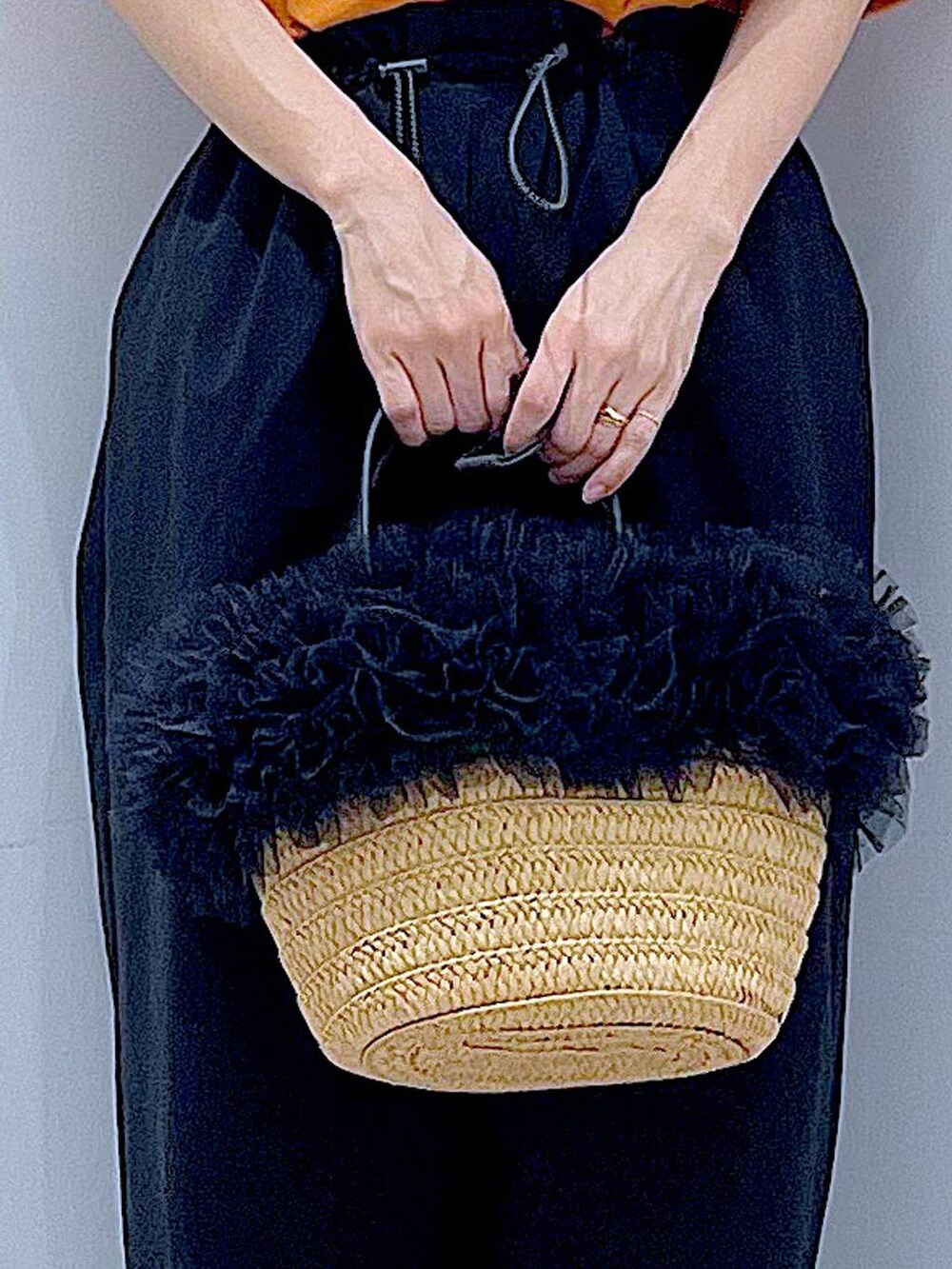 ベージュ系のショルダーバッグ、ブラック系のサンダル、オレンジ系のTシャツ/カットソーを着用したレディースの夏コーディネートの9枚目の写真