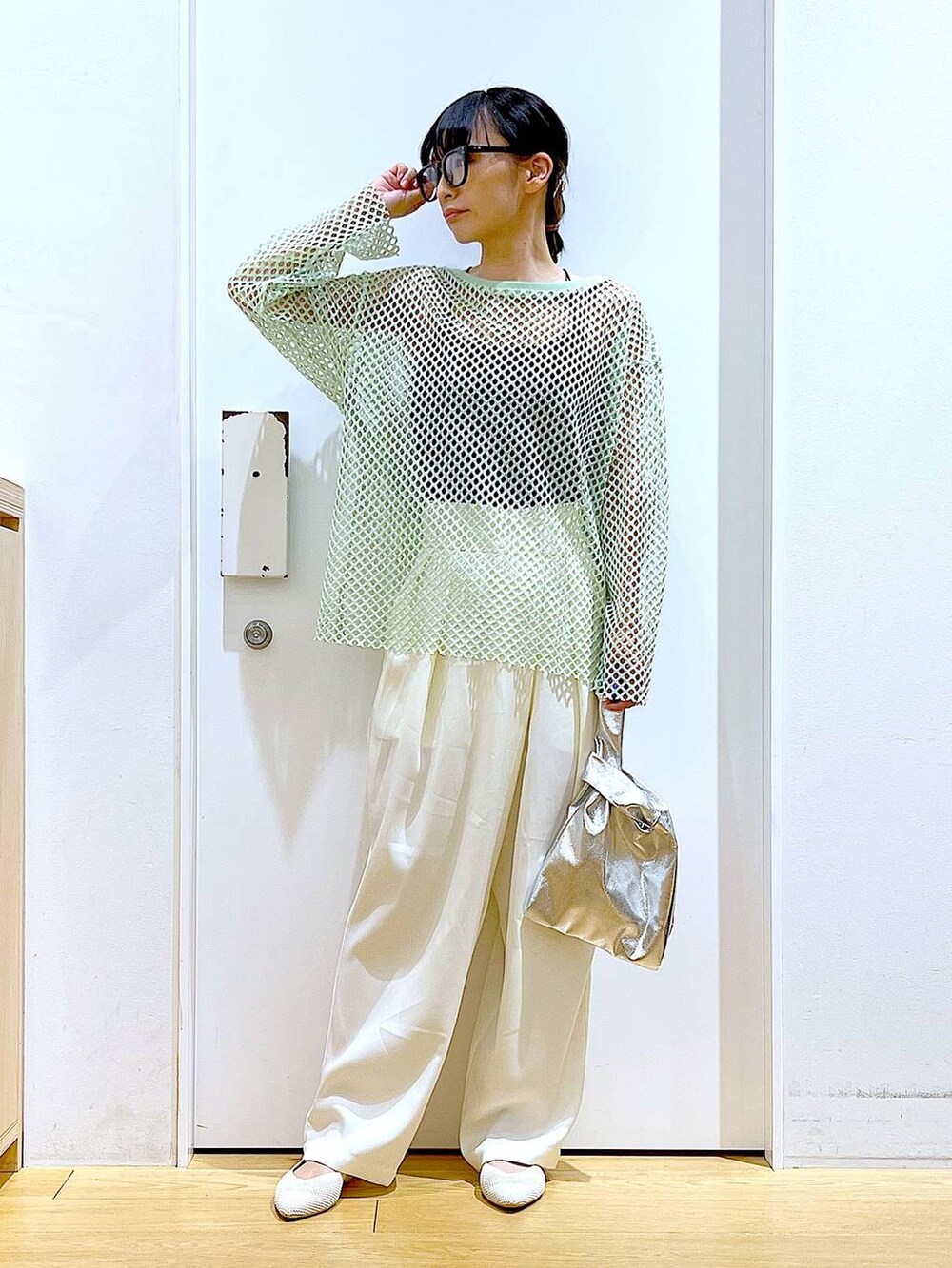 シルバー系のショルダーバッグ、グリーン系のTシャツ/カットソー、ホワイト系のパンプスを着用したレディースの春コーディネートの2枚目の写真