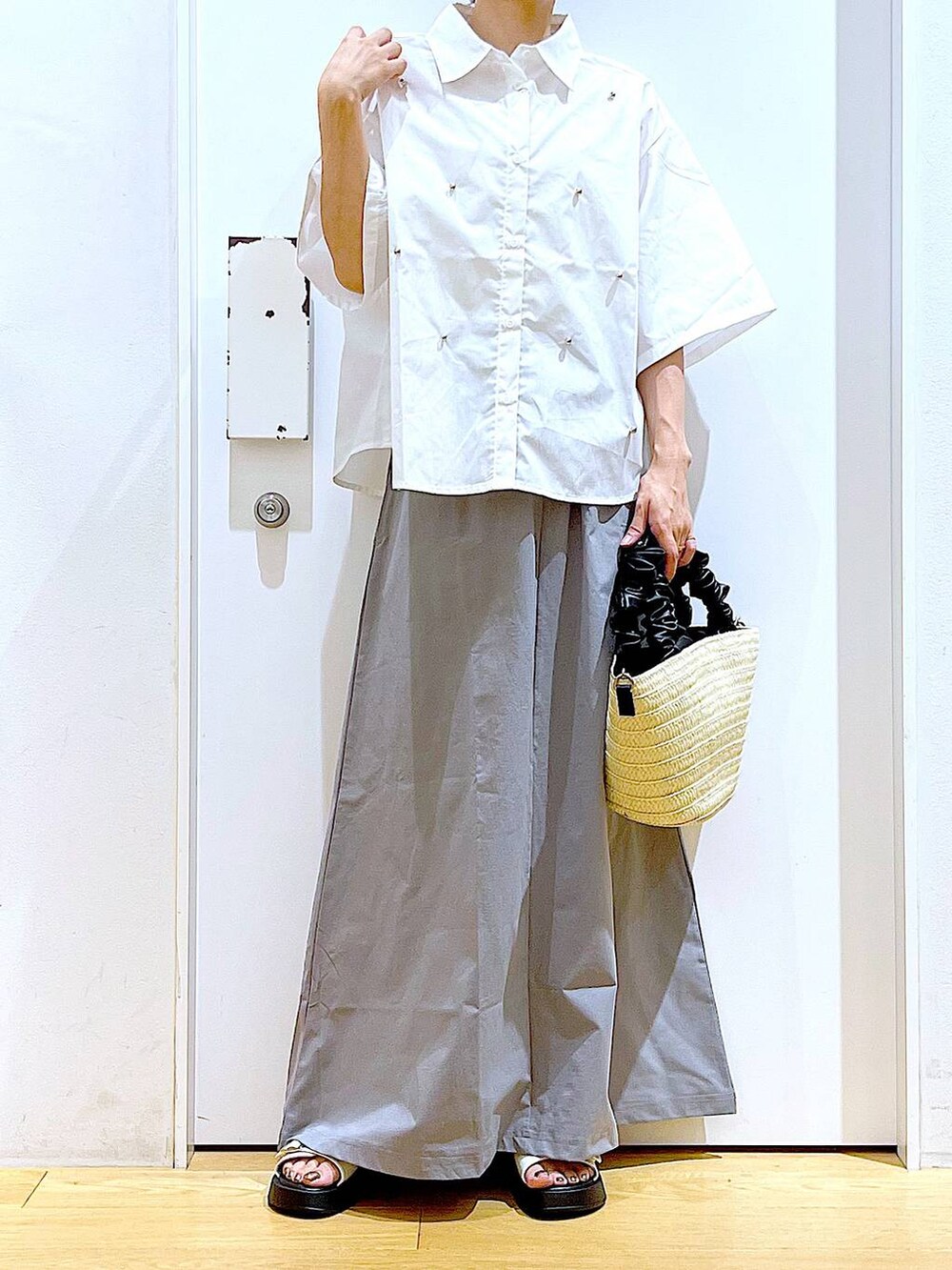 ホワイト系のサンダル、ホワイト系のショルダーバッグ、グレー系のスカートを着用したレディースの夏コーディネートの6枚目の写真