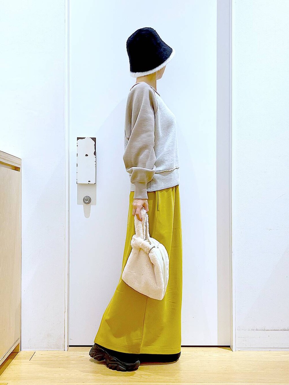 ホワイト系のショルダーバッグ、ブラック系のブーツ、ベージュ系のニット/セーターを着用したレディースの冬コーディネートの4枚目の写真