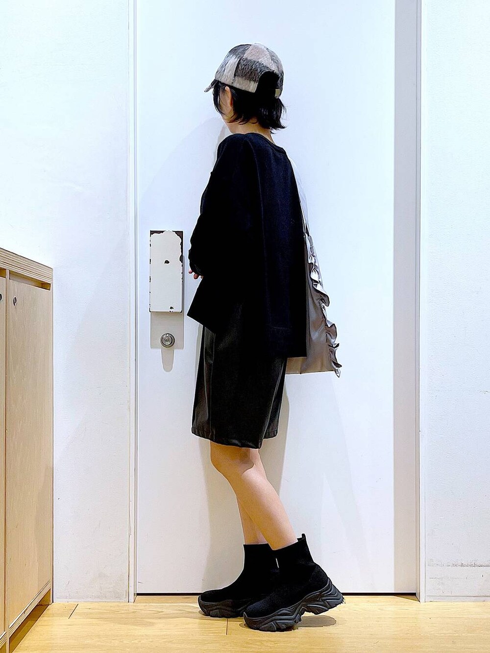 ブラック系のブーツ、グレー系のトートバッグ、ブラック系のその他パンツを着用したレディースの秋コーディネートの3枚目の写真