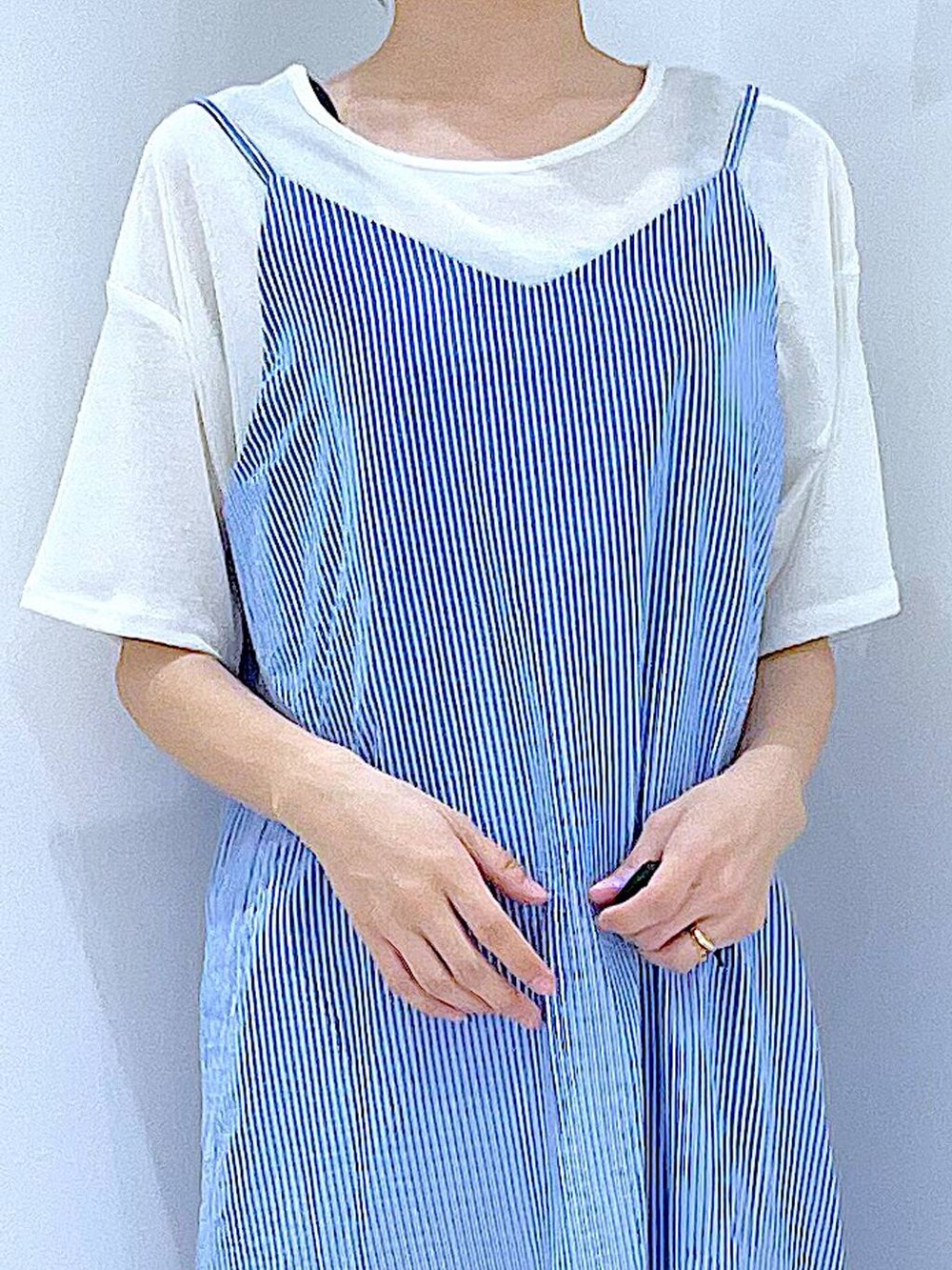 ブルー系のショルダーバッグ、ブラック系のサンダル、ホワイト系のTシャツ/カットソーを着用したレディースの夏コーディネートの7枚目の写真