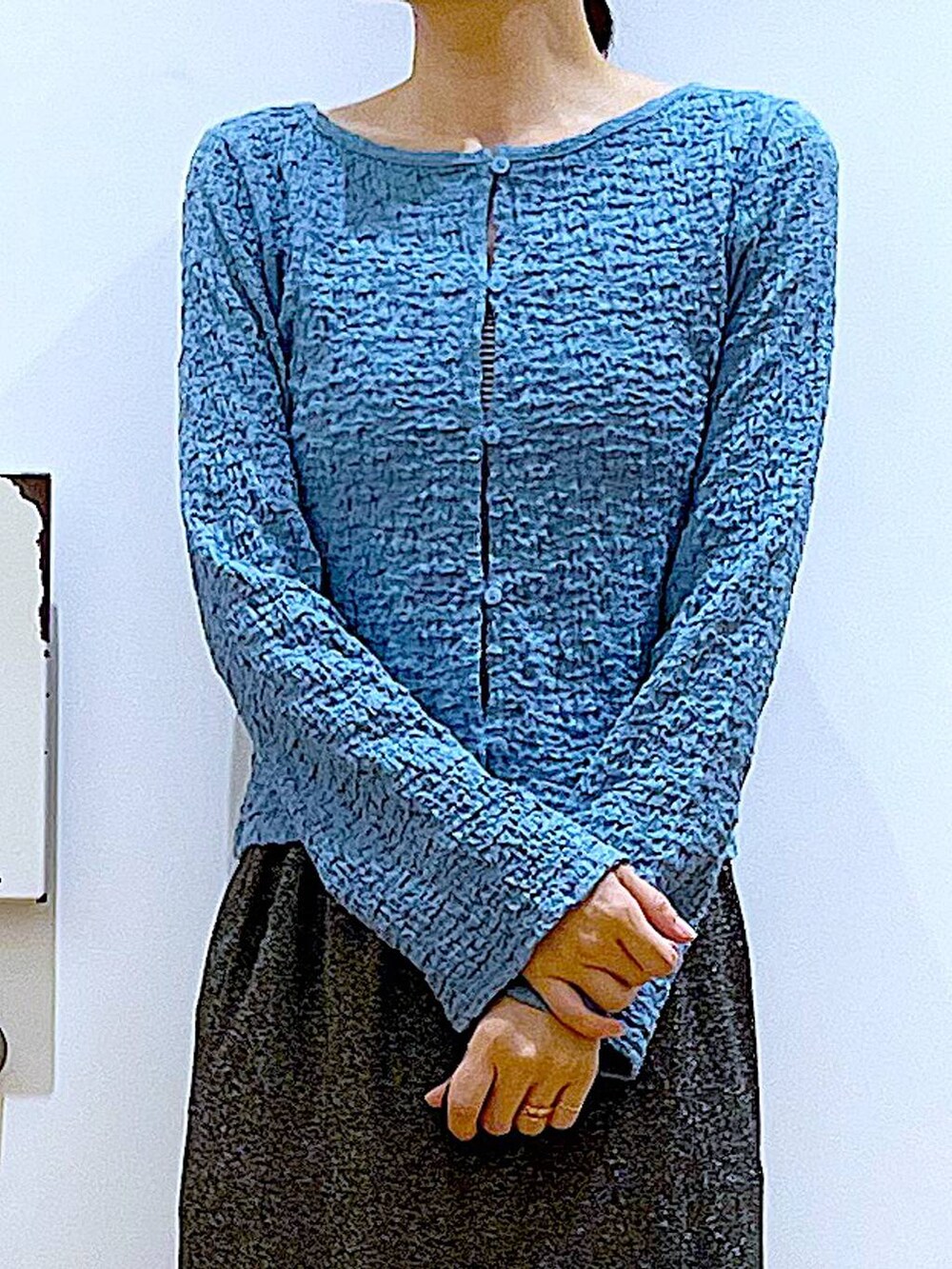 ブラック系のスカート、ブラック系のショルダーバッグ、ブラック系のパンプスを着用したレディースの春コーディネートの7枚目の写真