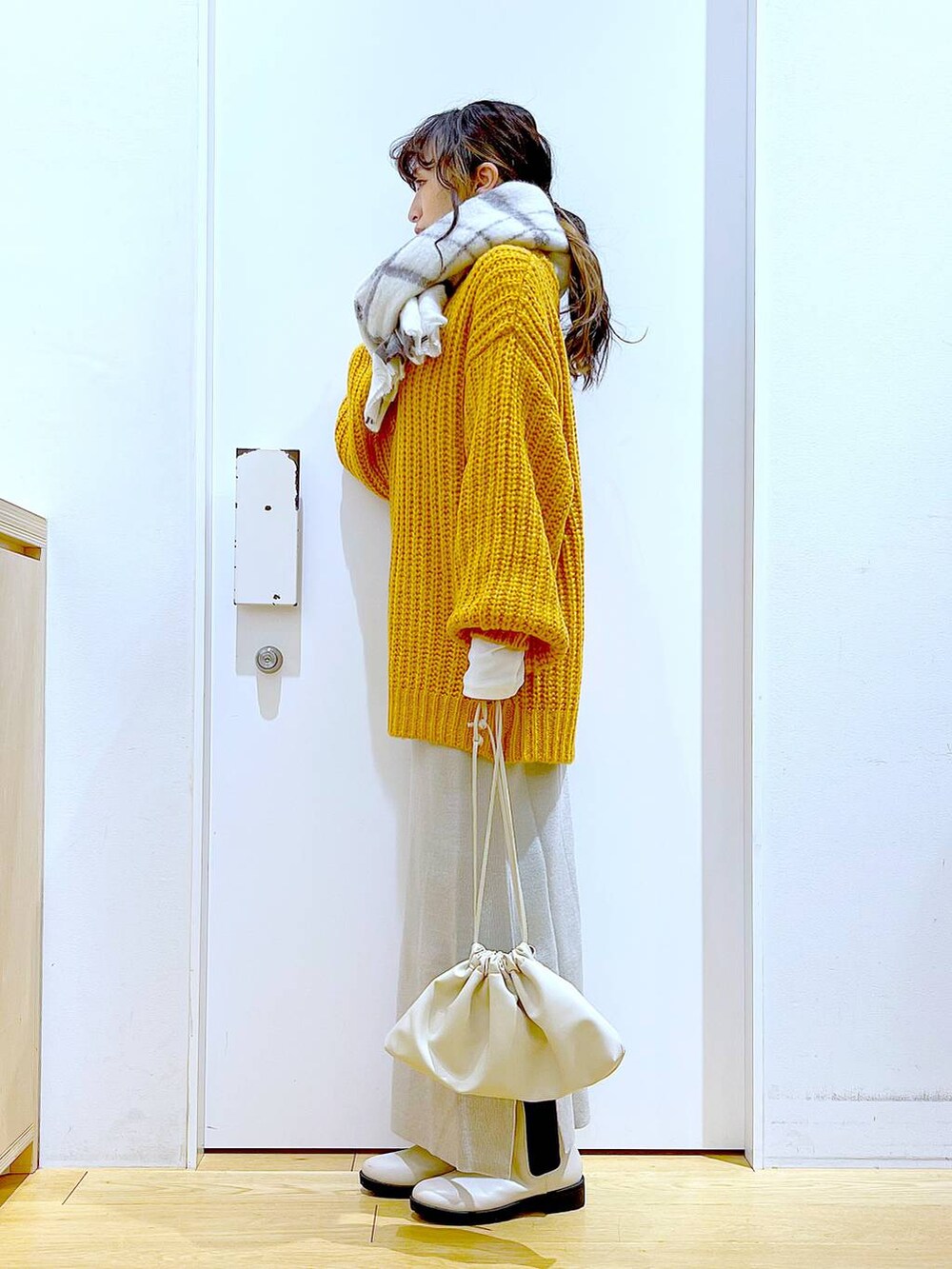 グレー系のスカート、ベージュ系のブーツ、ベージュ系のショルダーバッグを着用したレディースの冬コーディネートの3枚目の写真