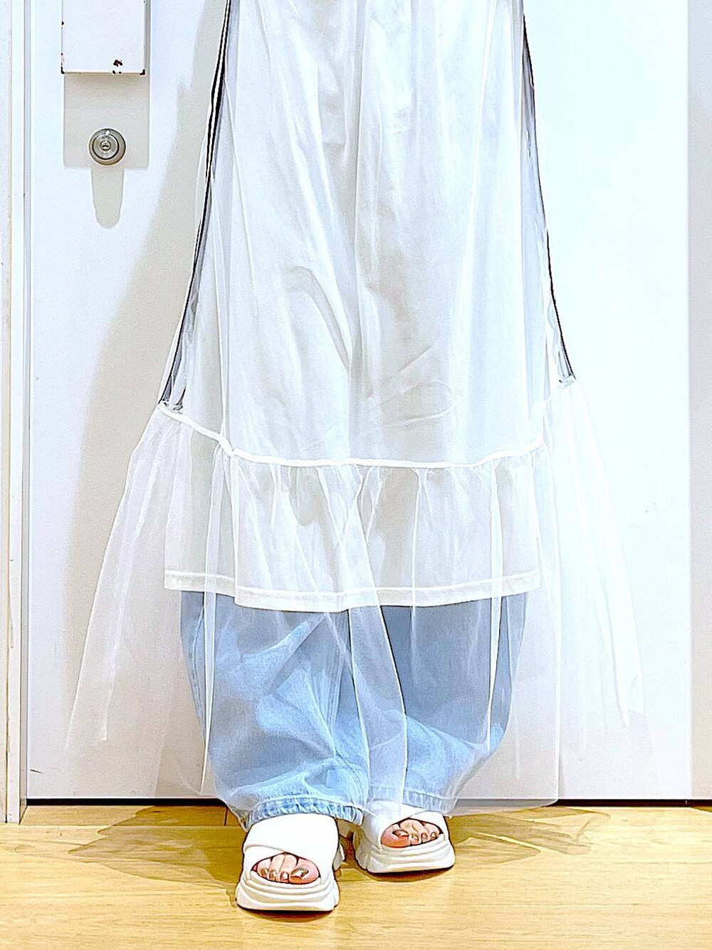 ホワイト系のサンダル、ブルー系のデニムパンツ、ホワイト系のトートバッグを着用したレディースの夏コーディネートの8枚目の写真