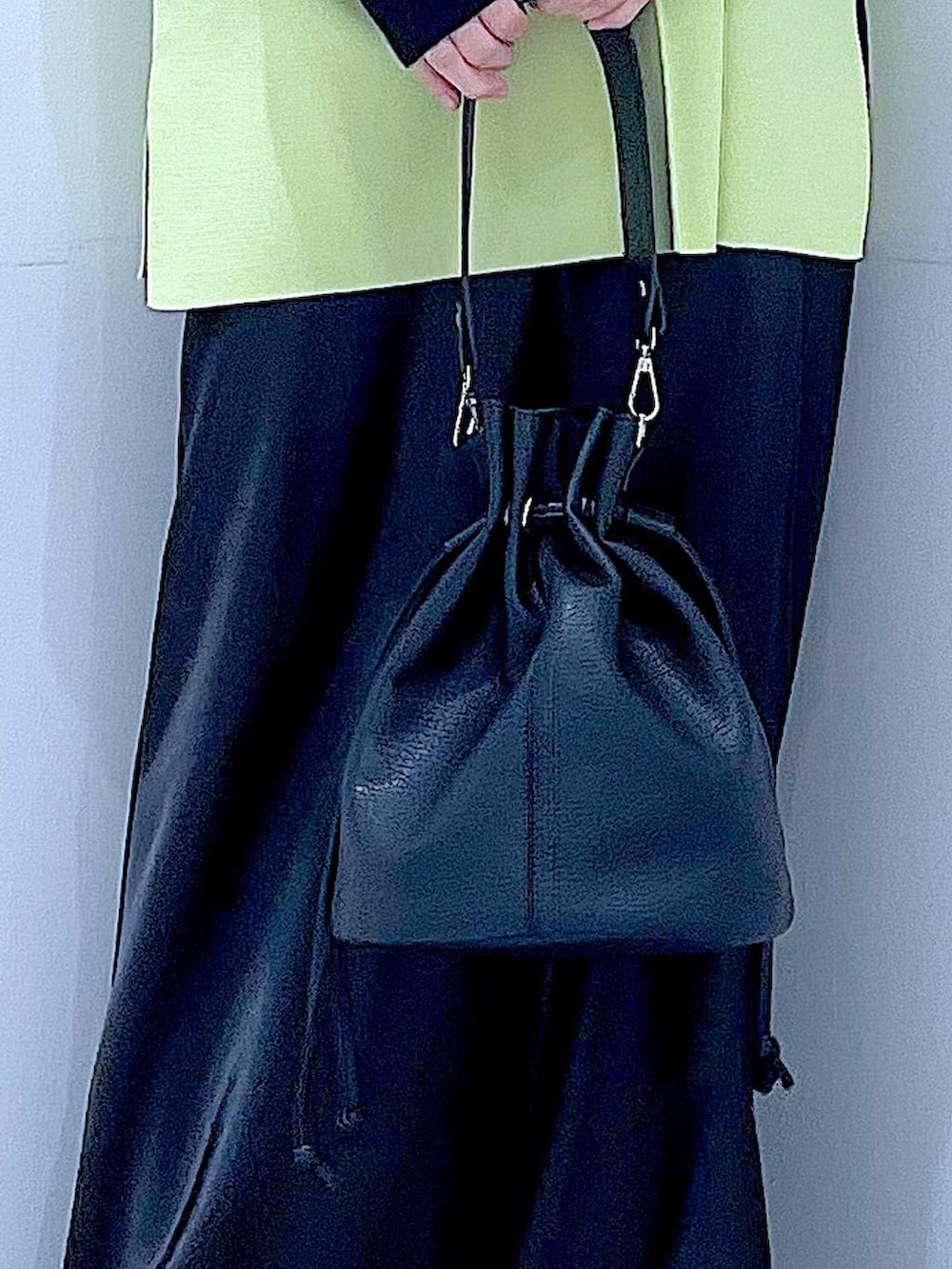 ブラック系のニット/セーター、ブラック系のスカート、ブラック系のローファーを着用したレディースの春コーディネートの9枚目の写真