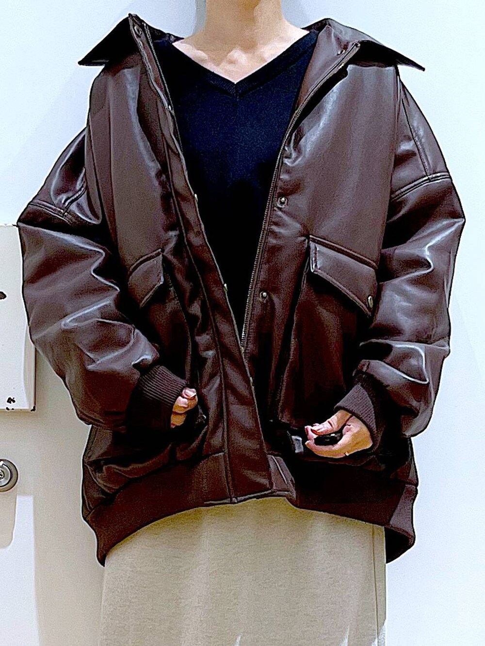 ブラウン系のブルゾン、ブラック系のブーツ、ブラック系のショルダーバッグを着用したレディースの冬コーディネートの7枚目の写真