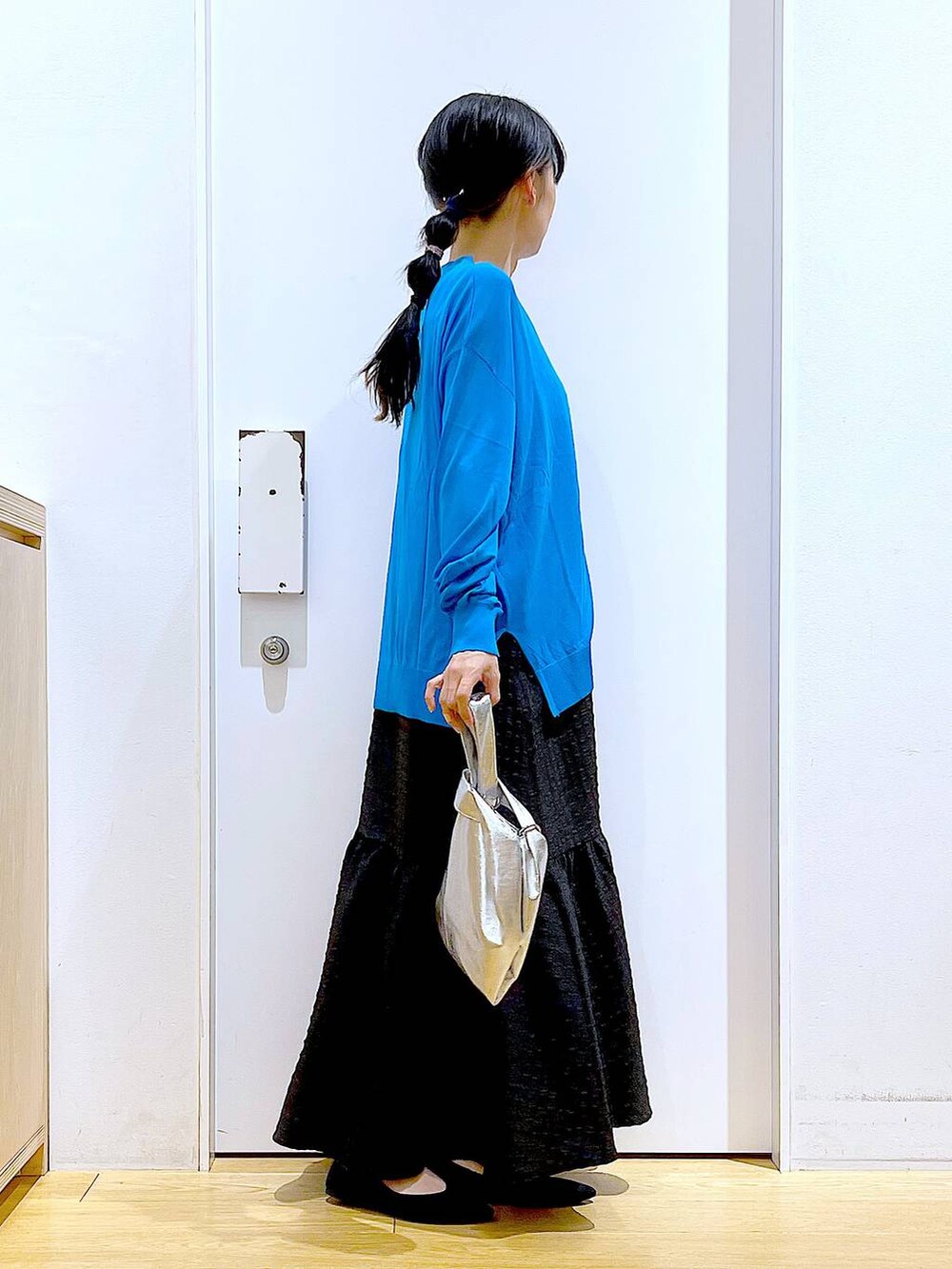 シルバー系のショルダーバッグ、ブラック系のワンピース、ブラック系のパンプスを着用したレディースの春コーディネートの4枚目の写真