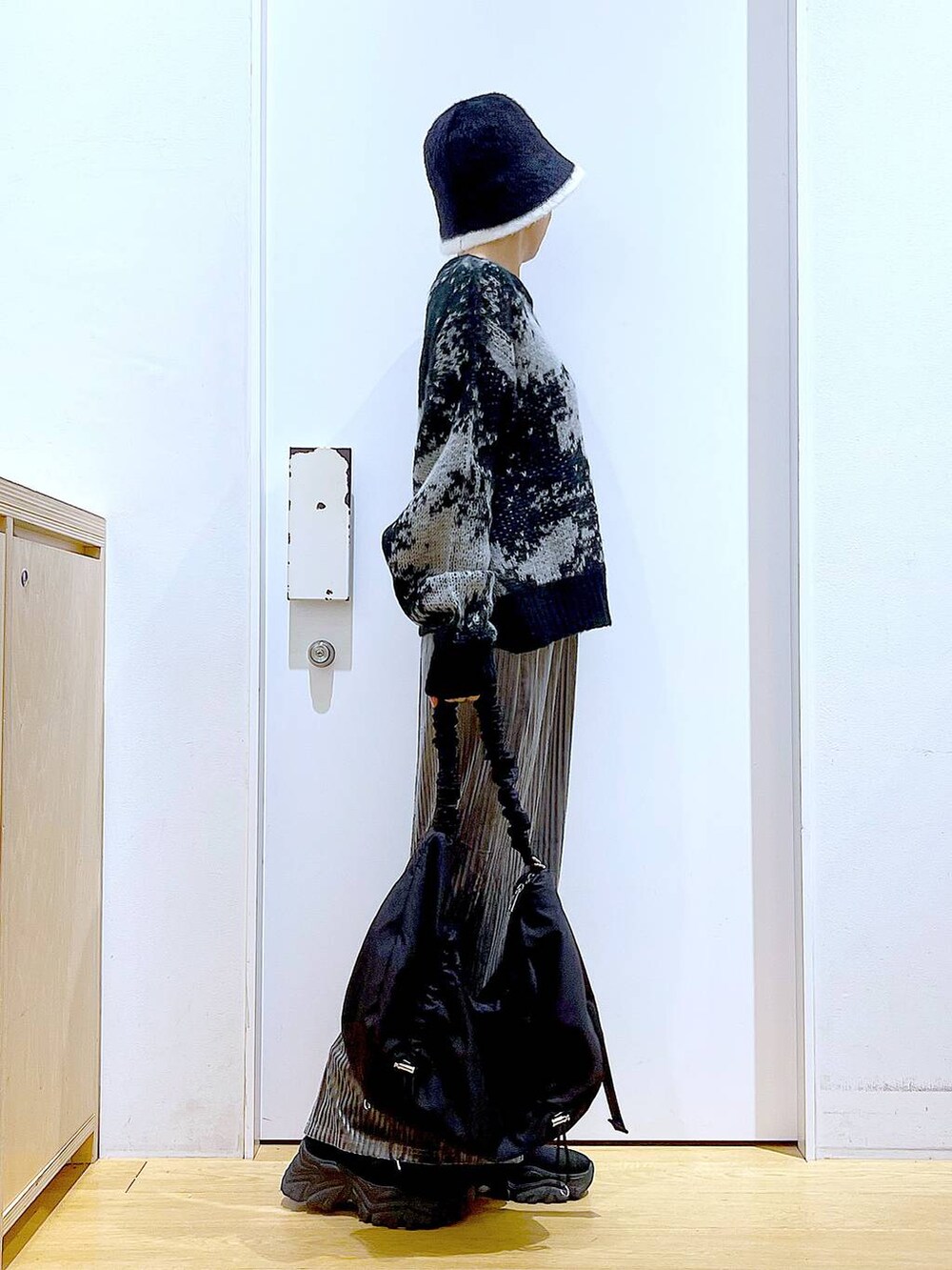 ブラック系のショルダーバッグ、グレー系のスカート、ブラック系のブーツを着用したレディースの冬コーディネートの4枚目の写真